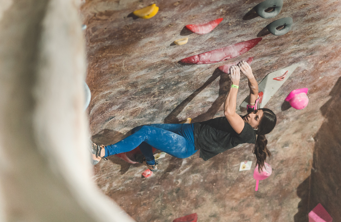 Two female climbers give each other a high five while a male climber looks on
