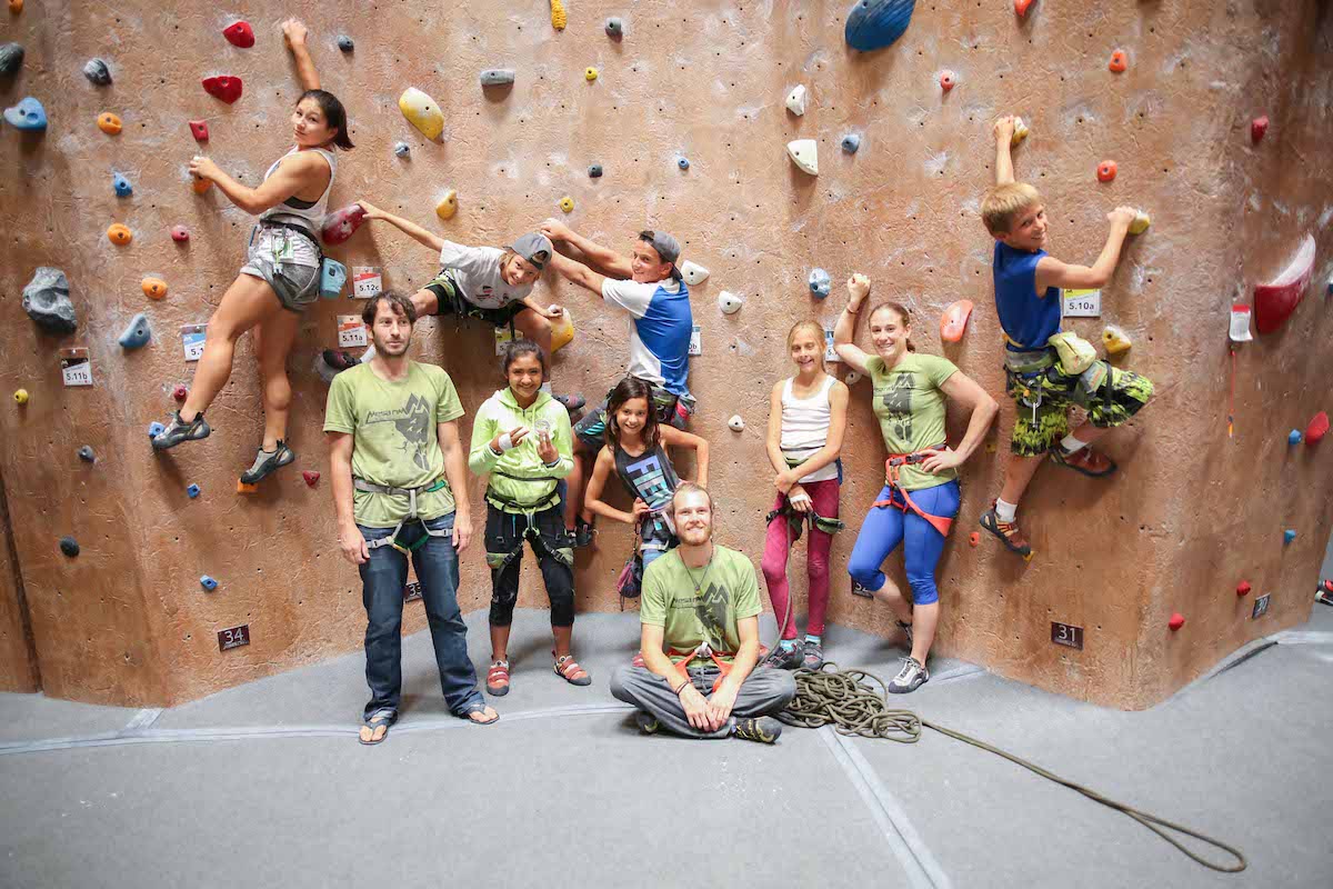 camp coaches and campers in front of climbing wall