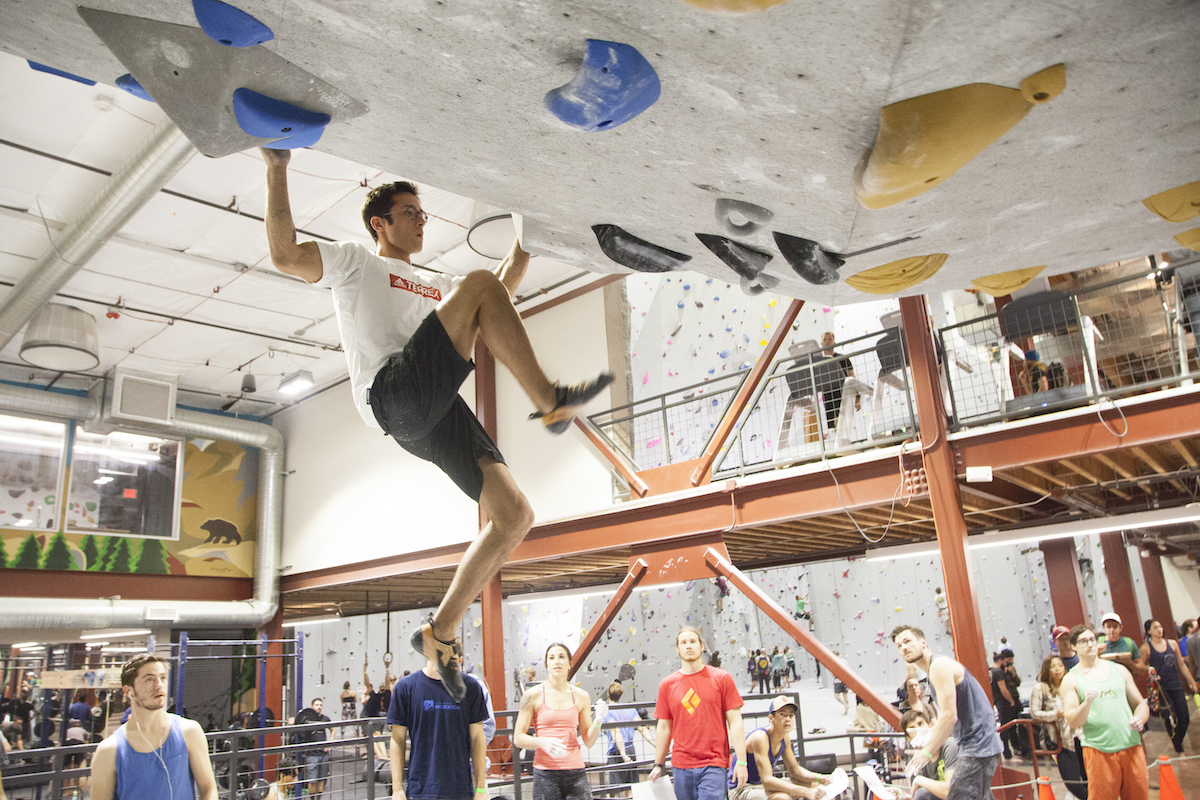 Two female climbers give each other a high five while a male climber looks on
